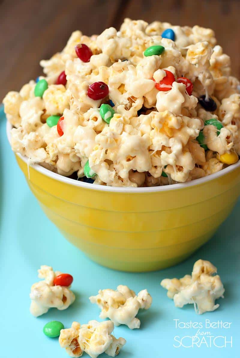 a bowl of white chocolate covered popcorn in a yellow bowl.