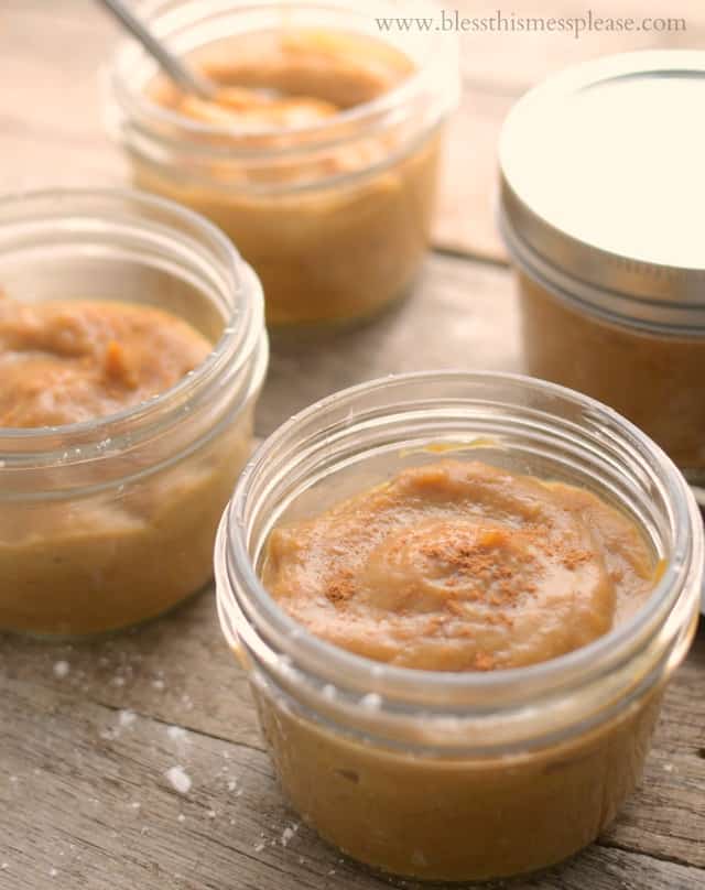 pumpkin pudding in small glass jars on wooden table.