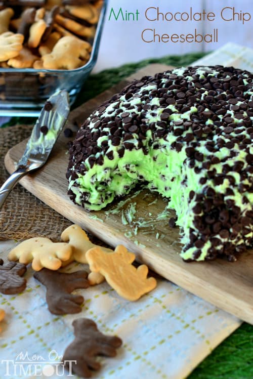 a mint cheeseball on a wooden platter with animal crackers on the side