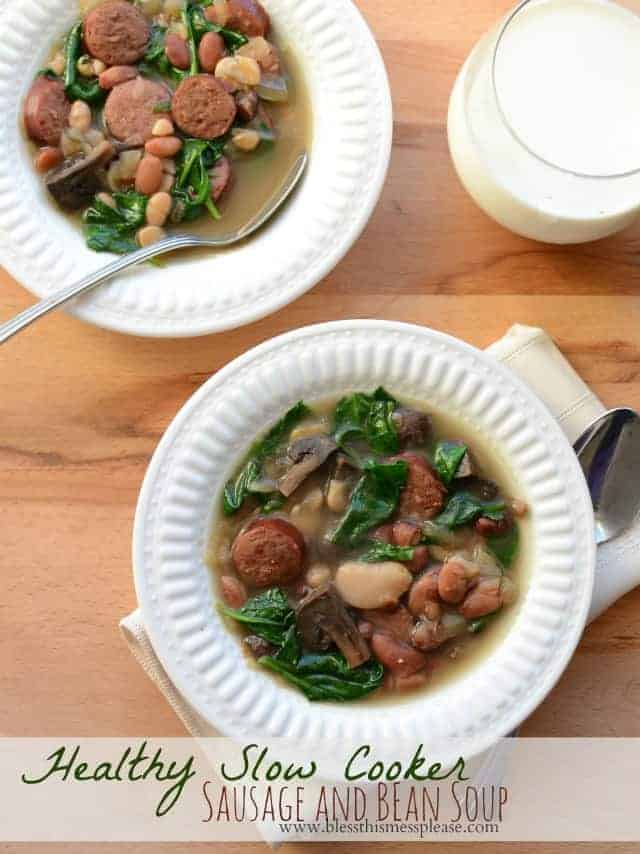 Top view of slow cooker sausage and bean soup with greens in a white bowl
