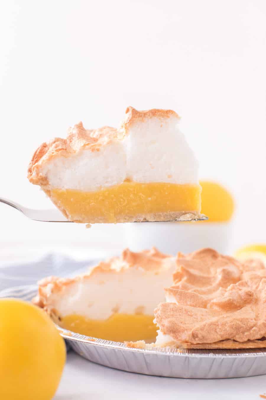 slice of lemon meringue pie being removed from the pie tin