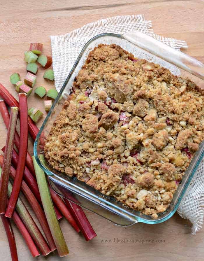 Rhubarb Crumb Bars in a glass pan with chopped rhubarb to the side