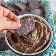 picture of a chip being scooped into black bean dip