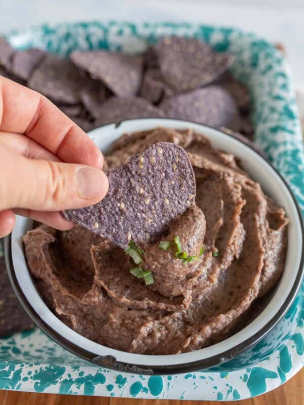 picture of a chip being scooped into black bean dip