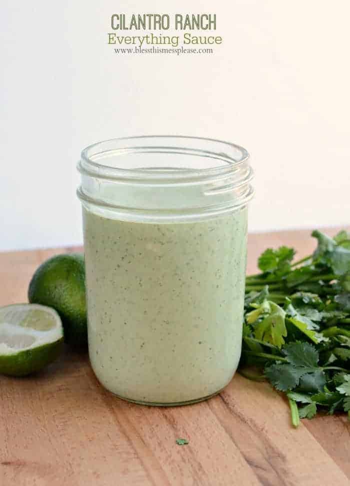 sauce in a jar with cilantro and lime on the side