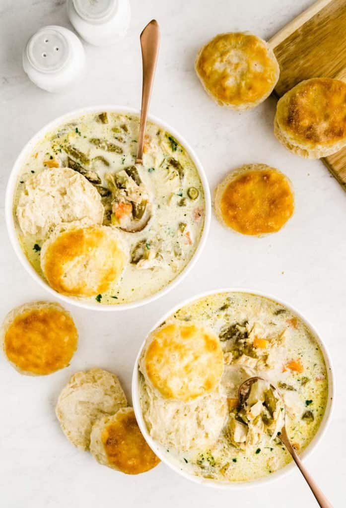 top view of two bowls of slow cooker chicken pot pie with biscuits around the bowls