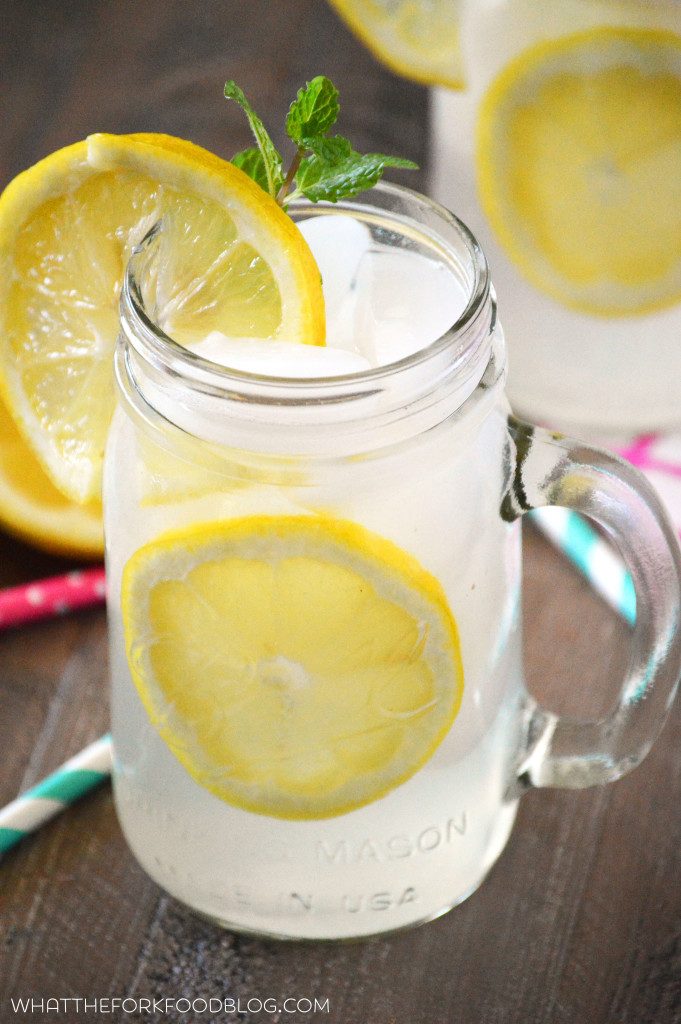 A mason jar of homemade lemonade with a lemon slice and sprig of fresh mint