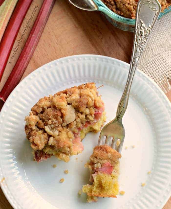 Rhubarb Crumb Bars on a white plate with a fork scooping a bite