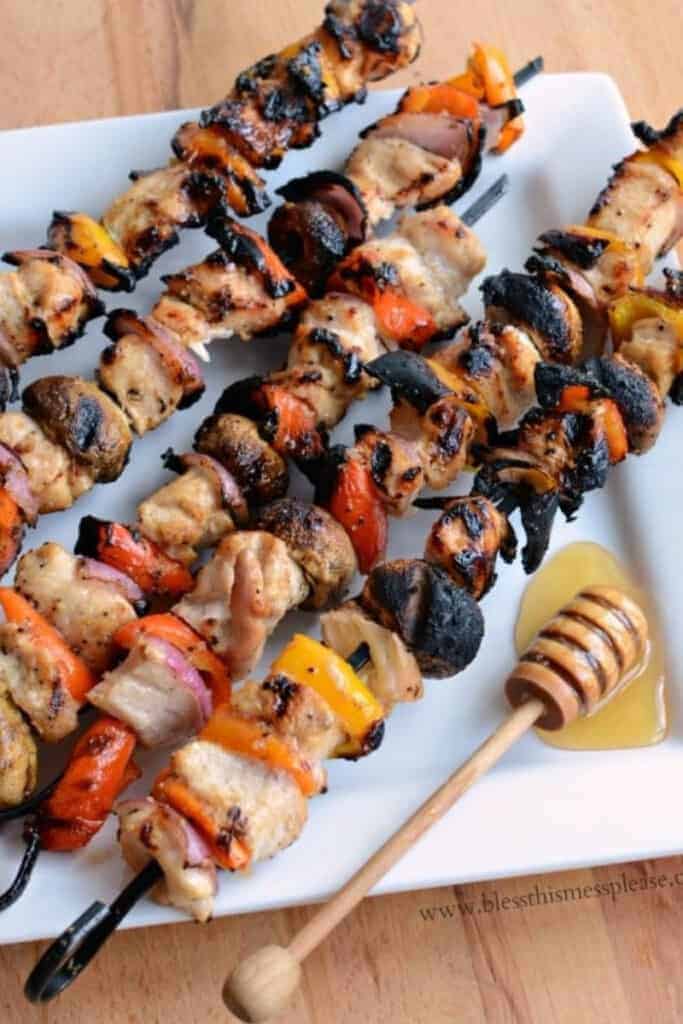 honey glazed chicken skewers on a white plate