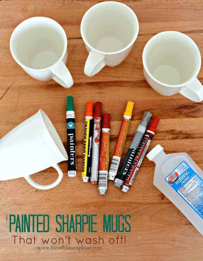 Painted Sharpie Mugs (that won't wash off!) The supplies to make painted sharpie mugs, including some oil-based paint markers, four plain white mugs, and a bottle of rubbing alcohol.