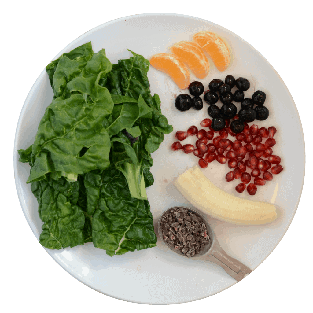 banana, orange, blueberries, pomegranate, cocoa nibs, and greens