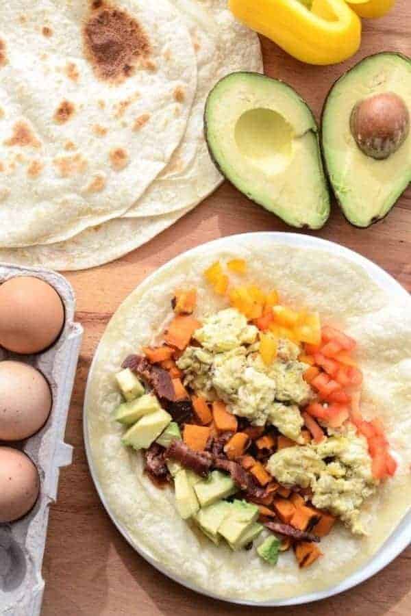 Quick, easy, and healthy Roasted Sweet Potato Breakfast Burritos made with roasted sweet potatoes, eggs, avocado and bacon. This recipe is done in 20 minutes and the perfect breakfast for dinner meal.