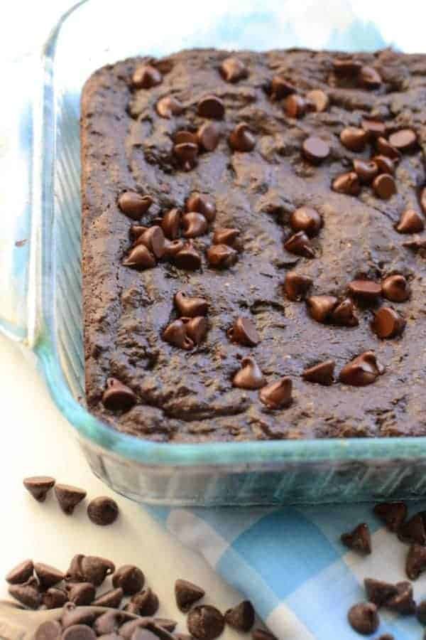 A square glass baking dish of brownies topped with chocolate chips