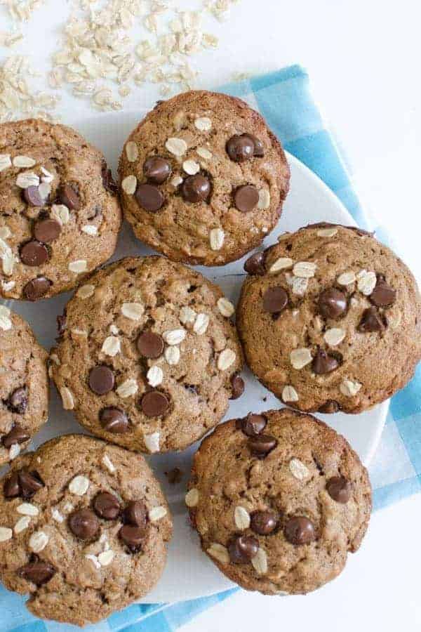 A batch of maple-sweetened banana muffins topped with chocolate chips and oats