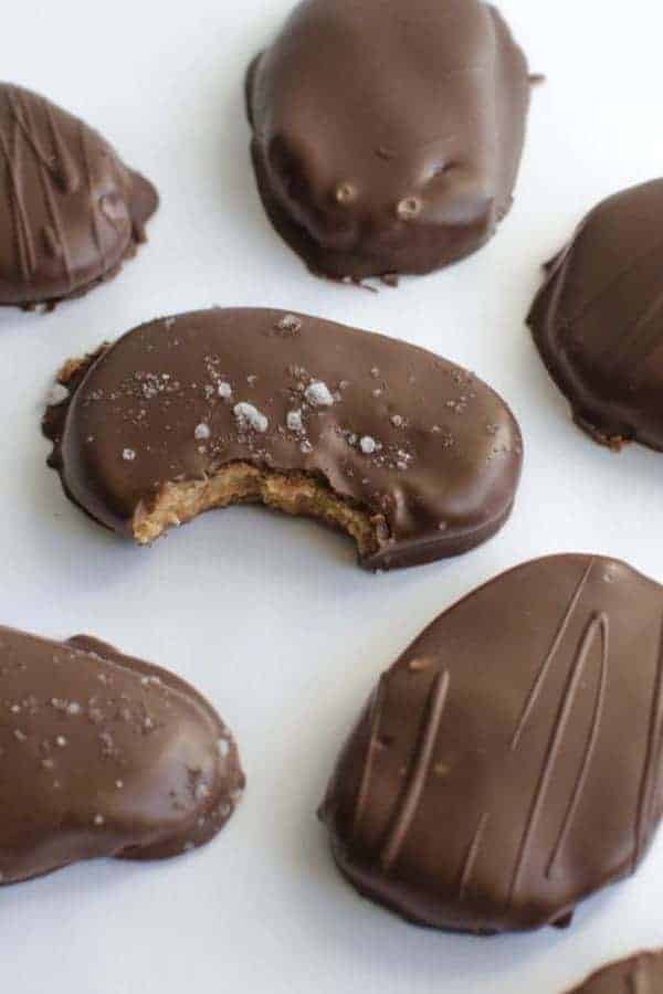 A few chocolate covered peanut butter ovals with a bite out of one