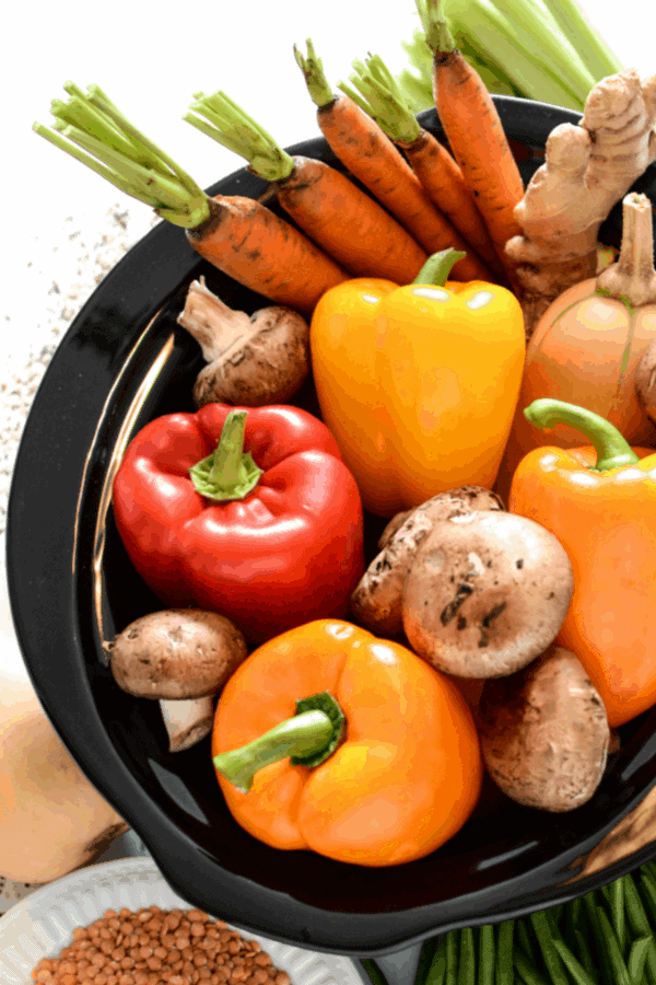 Whole peppers, mushrooms and carrots, and other vegetables in a bowl