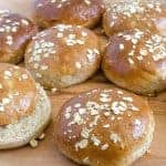 wheat and oat buns on a wood board