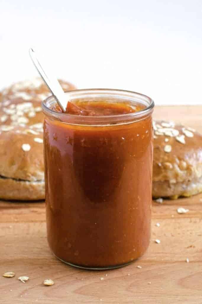 A jar of barbecue sauce with a spoon