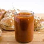 a jar of barbecue sauce next to wheat and oat buns