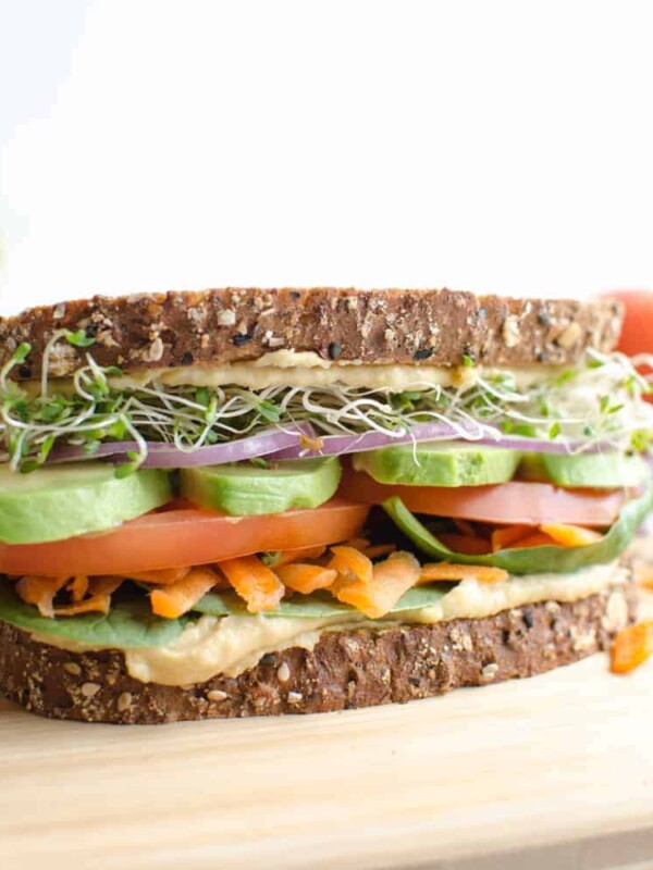The Ultimate Hummus and Veggie Sandwich piled high with veggies and sprout, loaded with creamy hummus, and held together with sturdy whole grain bread. Meatless sandwiches never looked so good!