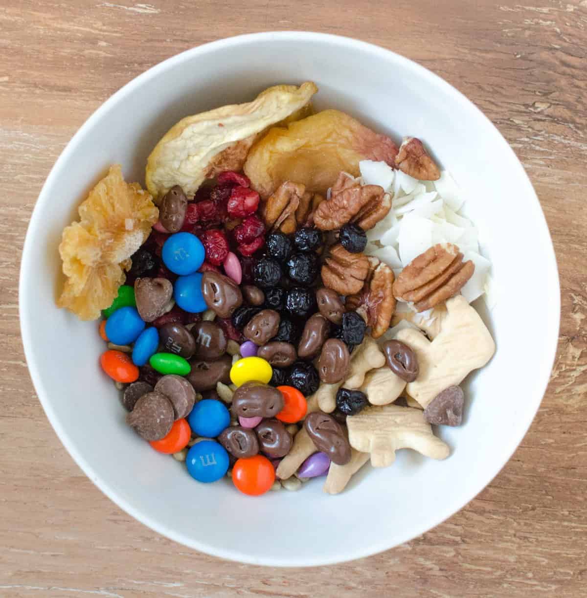 Trail Mix-Dried pineapple, white peaches, blueberries and cranberries, walnuts, sunflower seeds, animal crackers, chocolate-covered raisins, MM's, and milk chocolate chips.ananás seco, pêssegos brancos, mirtilos e airelas, nozes, sementes de girassol, bolachas de água e sal, passas cobertas de chocolate, M's, and milk chocolate chips.