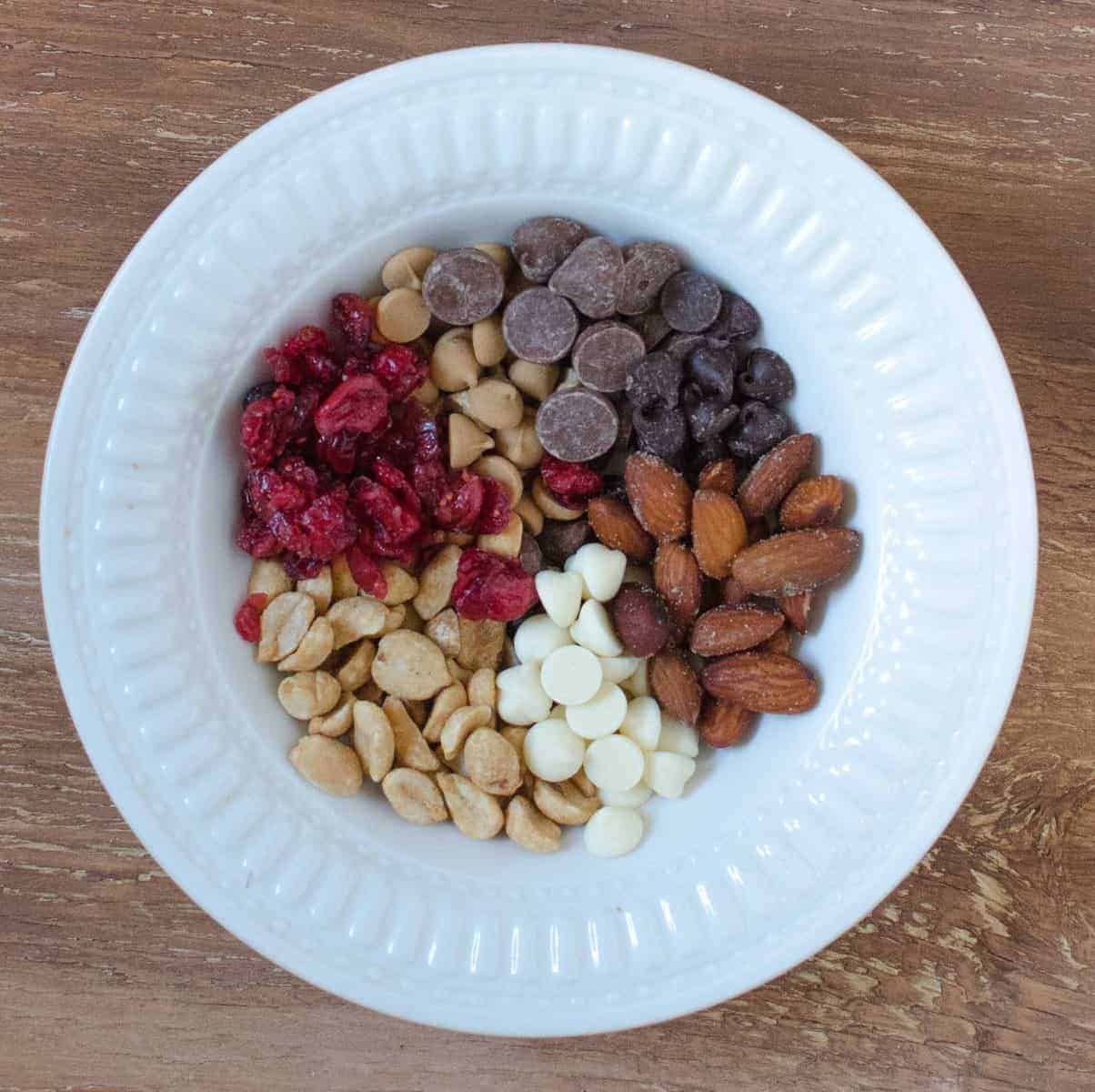 Trail Mix-mogyoró, sózott mandula, szárított áfonya, tej, félédes, fehér és mogyoróvaj chips.