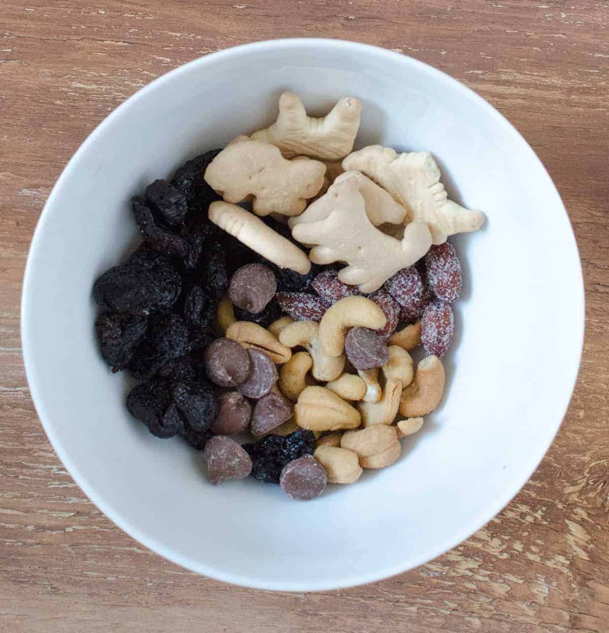 Trail Mix - gedroogde kersen, honing geroosterde amandelen, melkchocolade chips, cashewnoten, en dierlijke crackers.gedroogde kersen, geroosterde amandelen met honing, stukjes melkchocolade, cashewnoten en crackers van dieren.