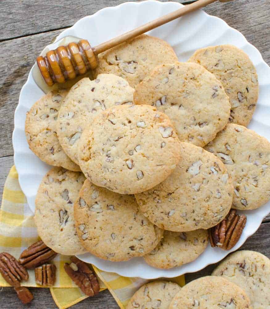 honey cookies on a white plate with a honey dipper sitting next to them