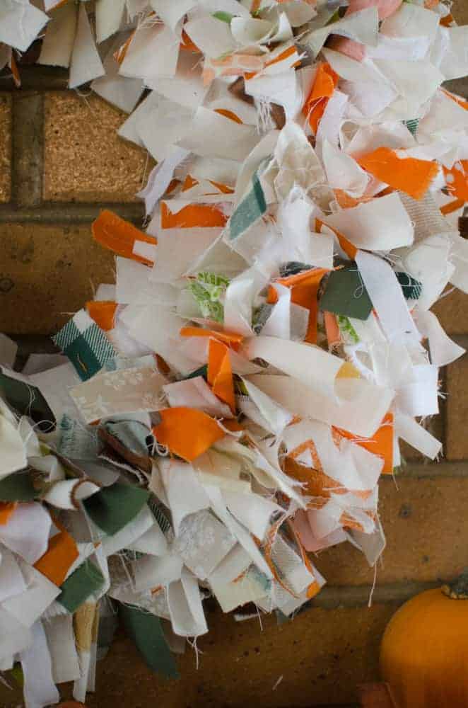 A DIY Fall Rag Wreath is an easy way to use up your fabric stash and get your house decked out for the season. Pop in a movie and get to tying that fabric!