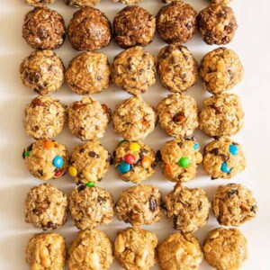 all 8 kinds of oatmeal energy balls all lined up in a 5 by 8 pattern on a white board.