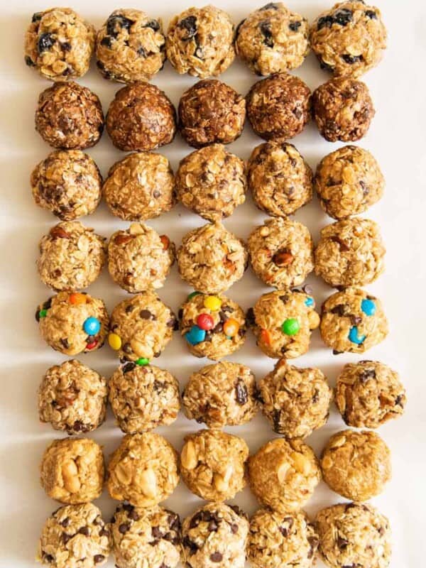 all 8 kinds of oatmeal energy balls all lined up in a 5 by 8 pattern on a white board.