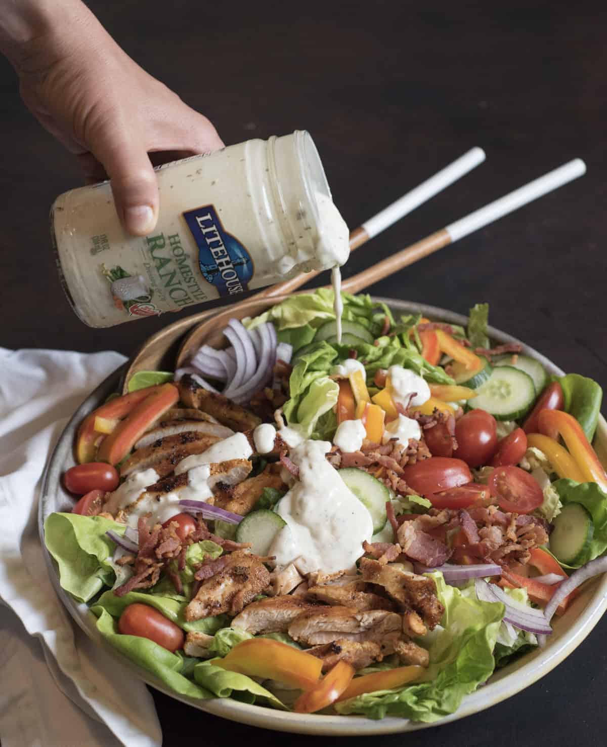 The BEST Chicken Bacon Ranch Salad of summer is a main dish green salad topped with all of your favorite things such as pan seared chicken, bacon, tomatoes, cucumber, and plenty of ranch dressing!