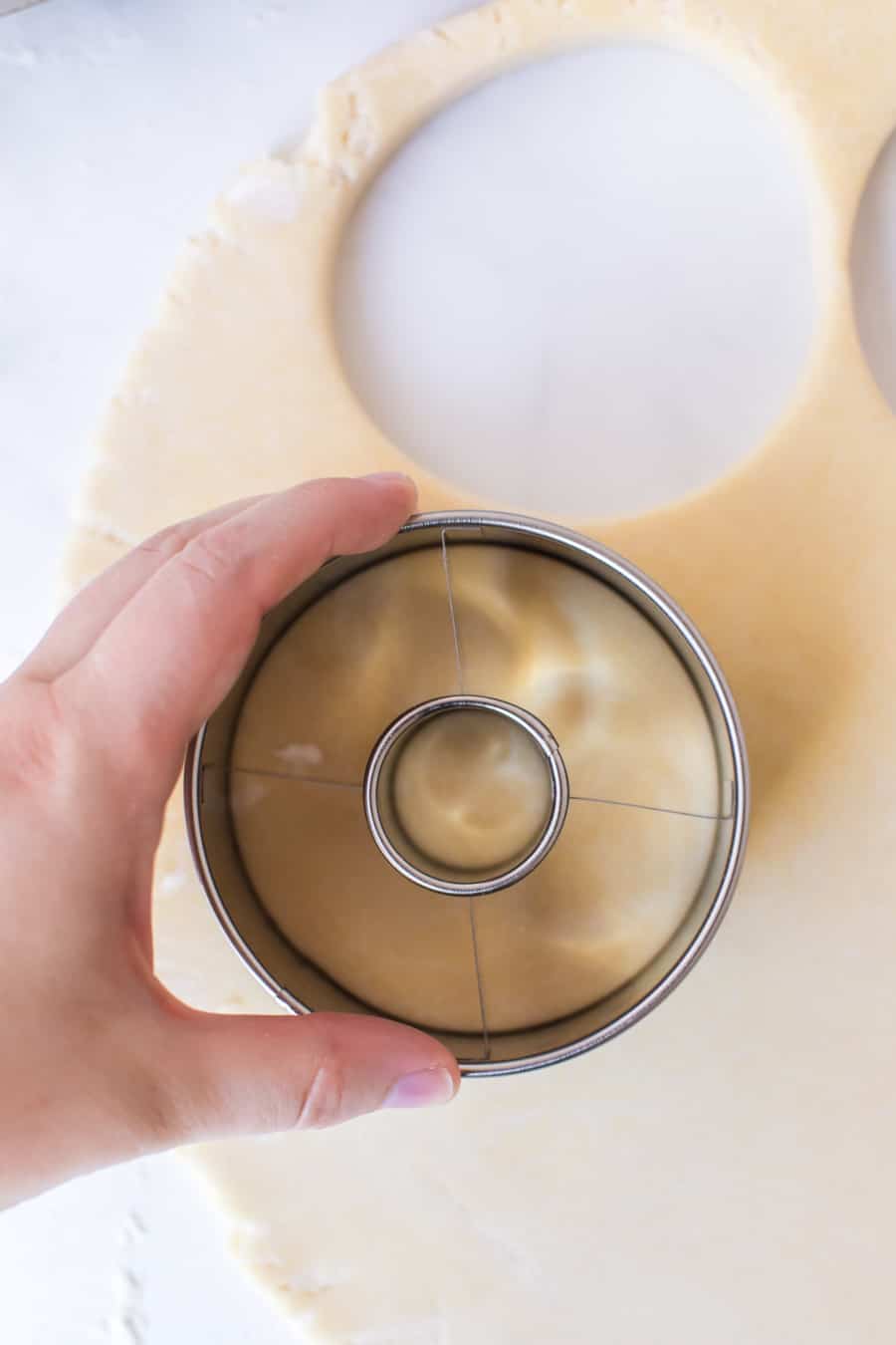 Picture showing how to cut out donuts using a doughnut cutter.