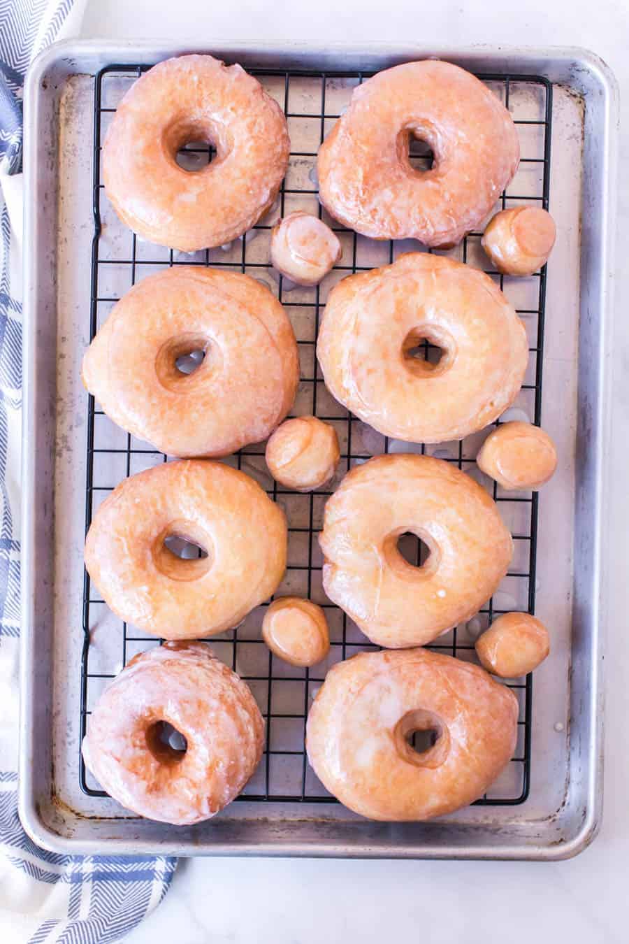Baking rack full of homemade glazed donuts.