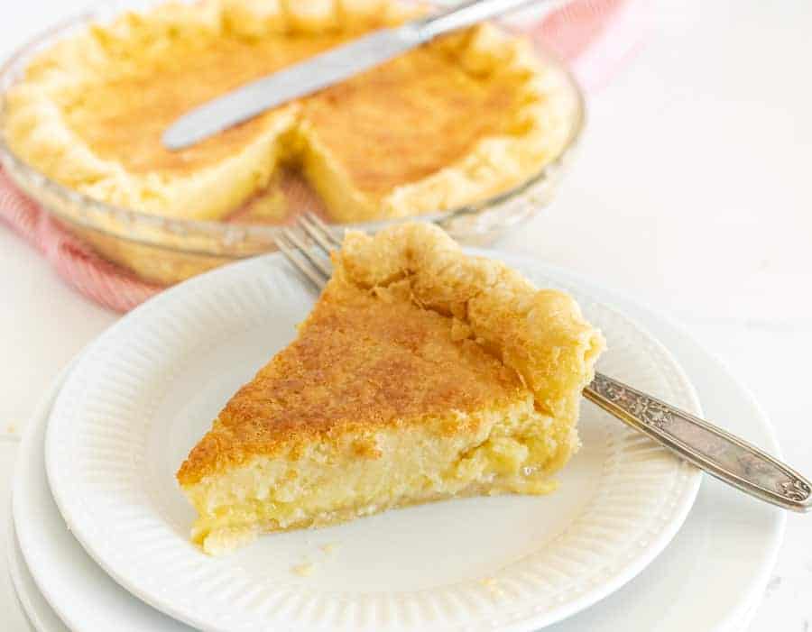 slice of buttermilk pie on a white plate with a fork