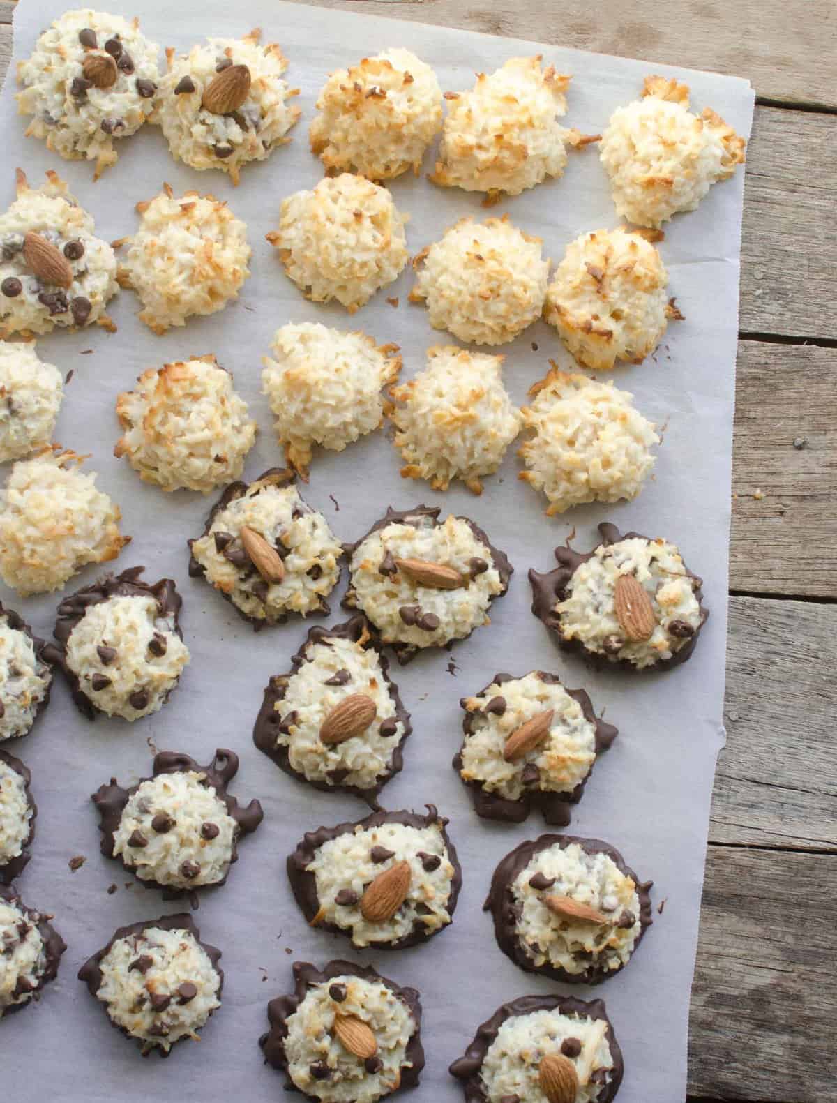 Simple and easy Coconut Macaroons made three different ways! Coconut, chocolate, and almond chocolate and you can make a few of each variety from one batch of cookies. Top view coconut macaroons in three varieties on white parchment paper.