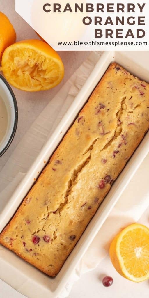 photo of a loaf of cranberry orange bread in a loaf pan with the words cranberry orange bread on top