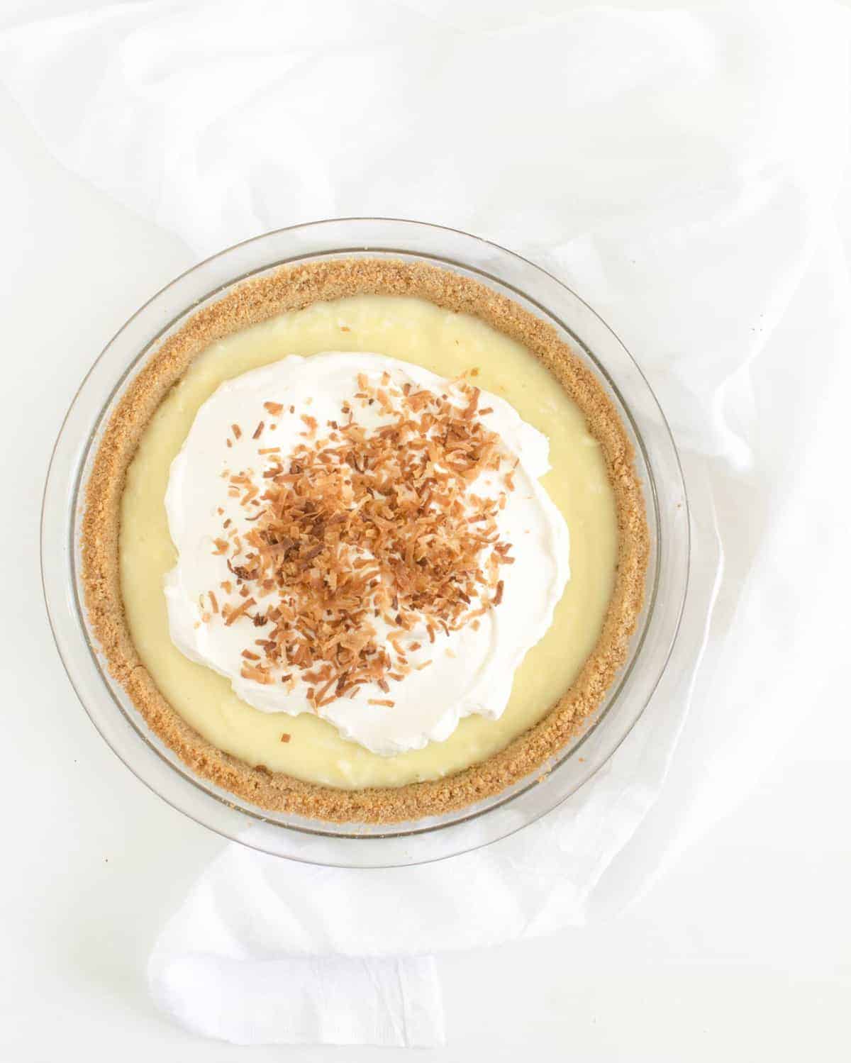 Simple and delicious homemade coconut cream pie in a graham cracker crust topped with real whipped cream and toasted coconut.