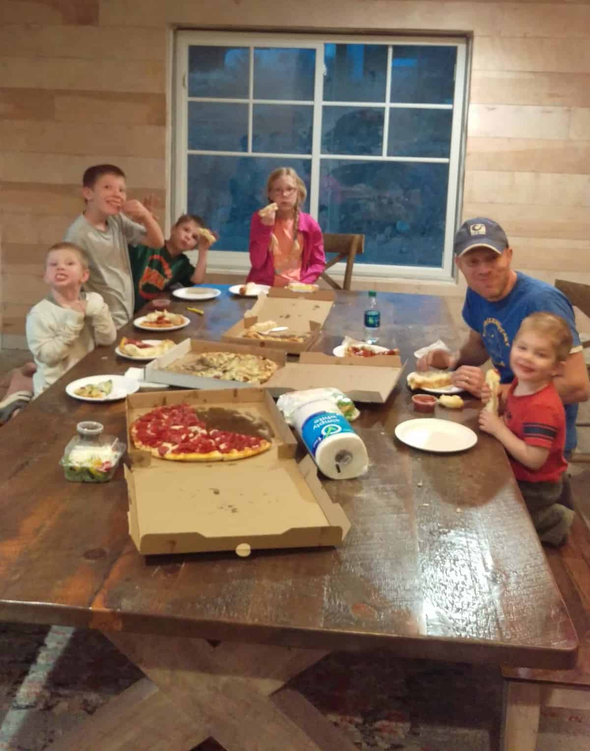 a family around their new kitchen table eating pizza