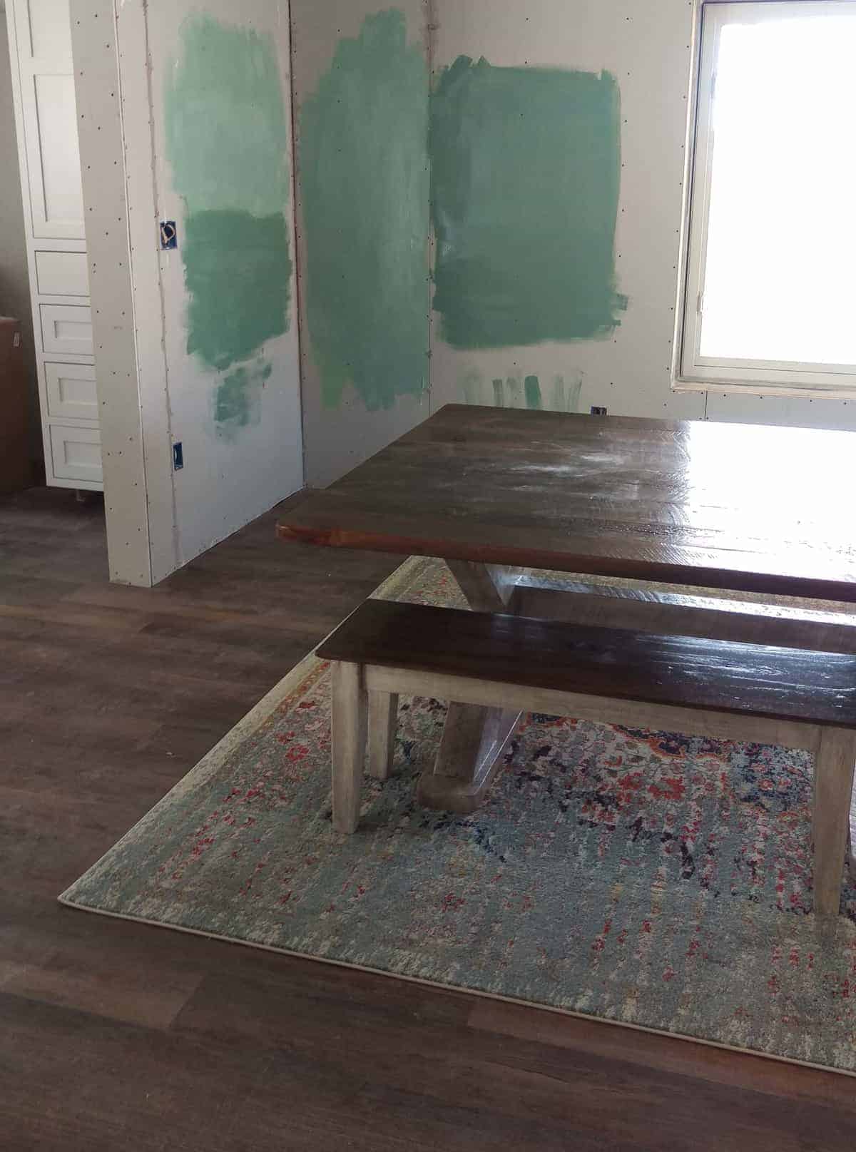 two shades of green paint being tested on the dining room walls