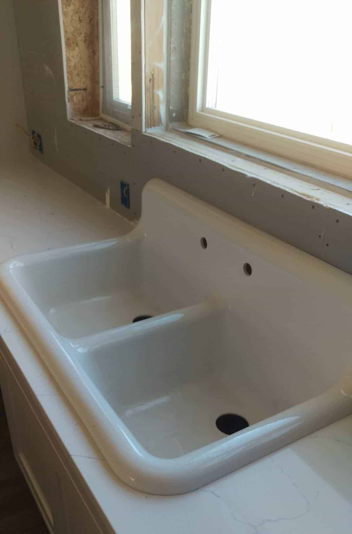 a large white vintage style sink installed in the kitchen