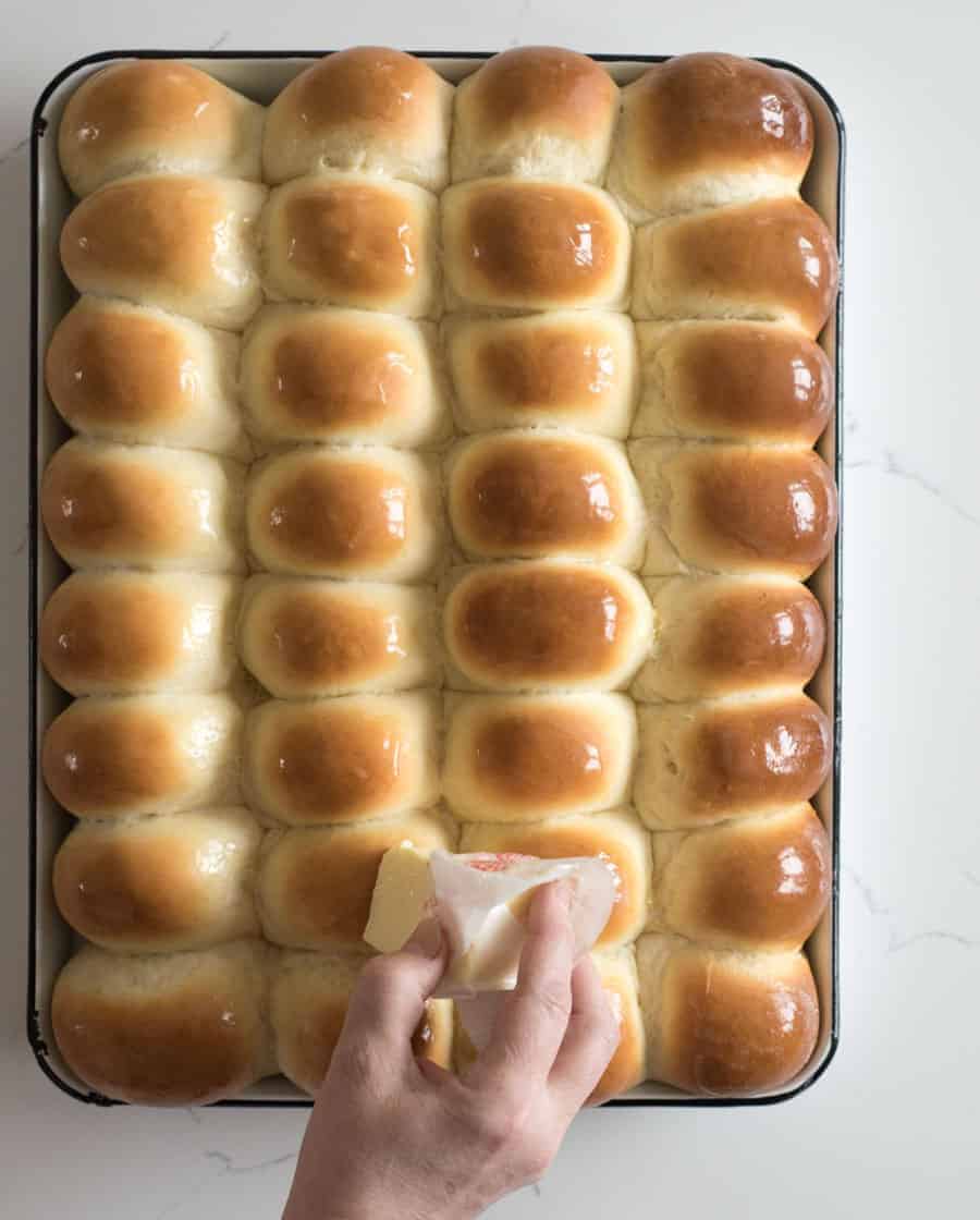 light and fluffy dinner rolls fresh out of the oven and having butter rubbed on the tops