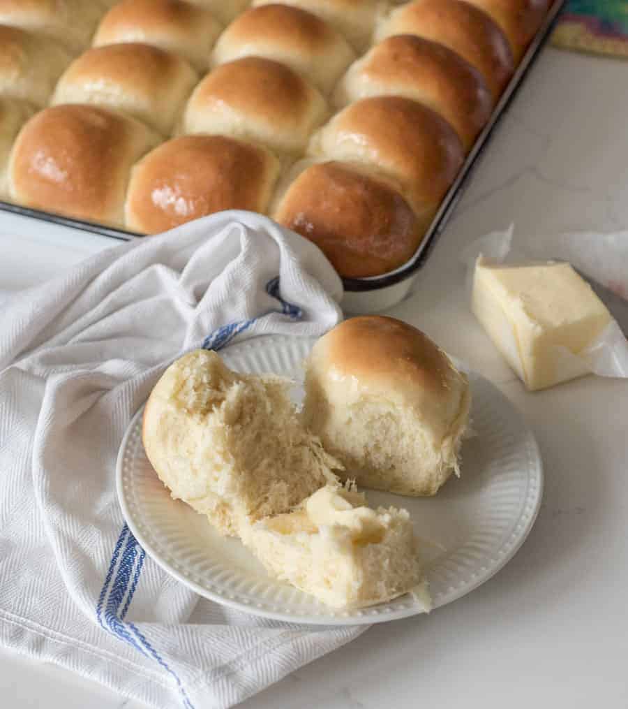 open dinner roll on plate with fresh butter in the middle melting