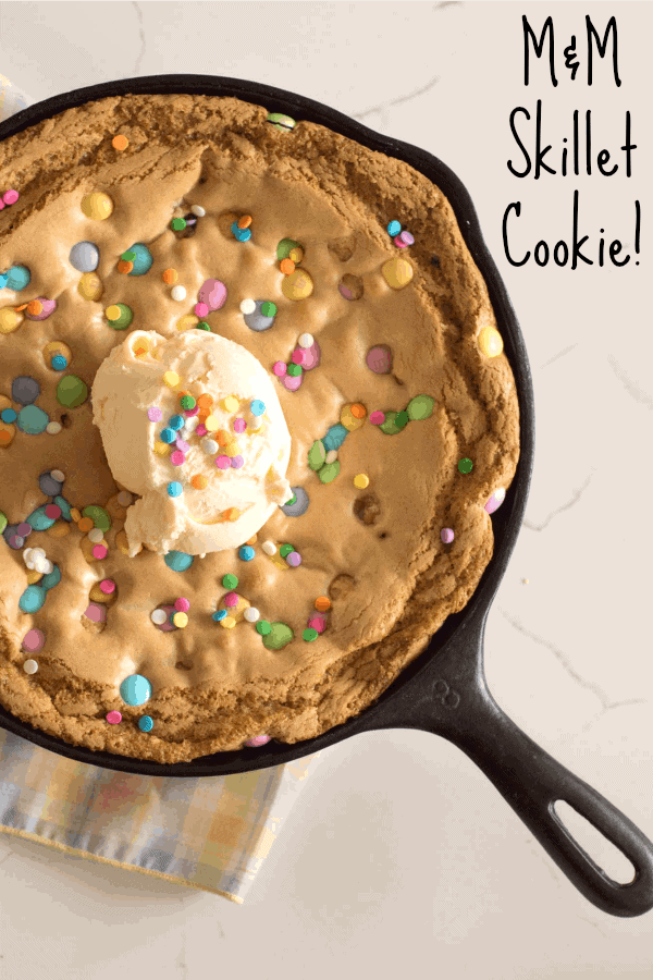 Warm and gooey skillet cookie recipe made with butter and brown sugar and topped with M&M's and perfect with a scoop of ice cream.