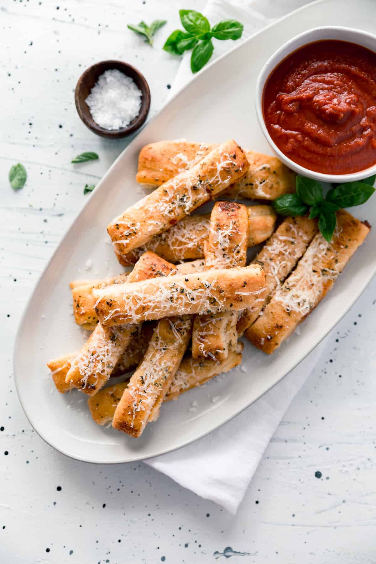 Plate of cheesy pizza sticks and cup of sauce