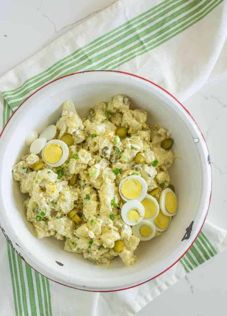 Bowl of potato salad with eggs and pickles
