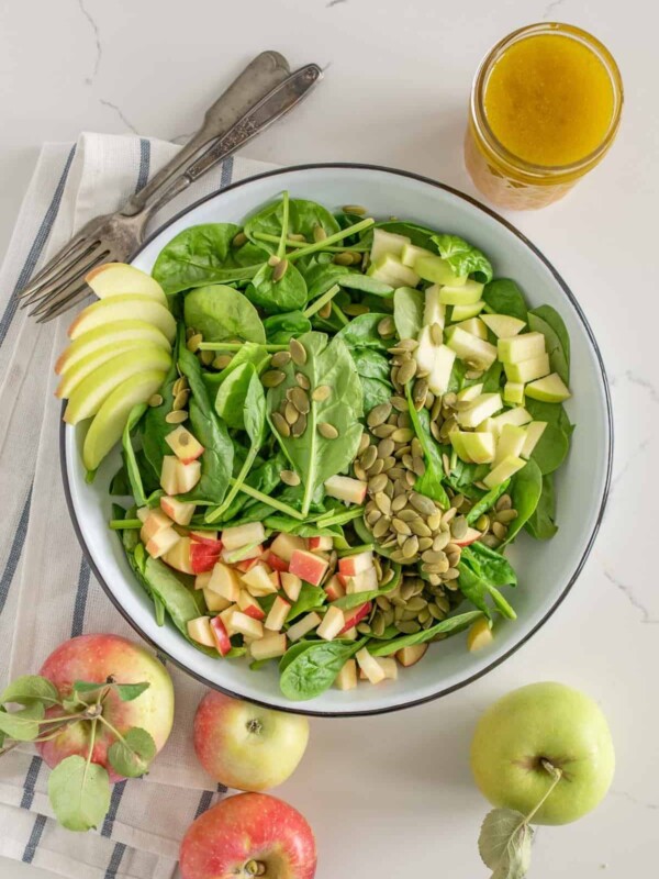 Bowl of spinach salad with apples and apple vinaigrette