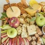 Platter with cheese, apple slices, crackers, and caramel dip