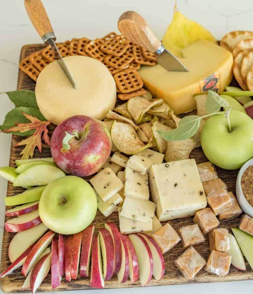 Platter with cheese, apple slices, crackers, and caramel dip