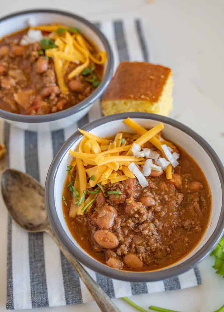 Two bowls of slow cooker chili with cornbread